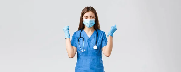 Covid-19，防止病毒、健康、保健工作者和检疫概念。鼓励快乐的女护士或穿着蓝色刷子的医生，庆祝，戴上医疗面具，成功的欢呼 — 图库照片