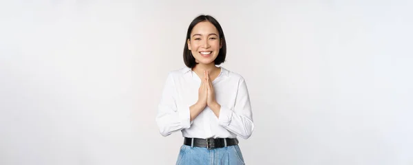 Porträtt av glad asiatisk flicka skrattar och ler, visar tack, namaste gest, tacksam för smth, står över vit bakgrund — Stockfoto