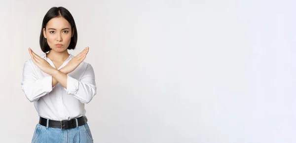 Image of young asian, korean girl student showing stop, cross prohibition sign, forbid smth, refusing, standing over white background — Stock Photo, Image