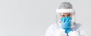 Covid-19, virüsün önlenmesi, sağlık, sağlık çalışanları ve karantina konsepti. Ciddi bir kadın doktor, kişisel koruyucu ekipman hemşiresi, solunum cihazını takın, kameraya bakın.
