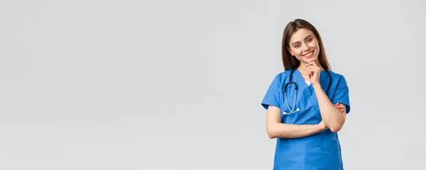 Pracownicy medyczni, opieka zdrowotna, koncepcja covid-19 i szczepień. Upbeat uśmiechnięta ładna pielęgniarka, lekarz w niebieskim fartuchu, klinika pracy, patrząc z entuzjastycznym aparatem wzrokowym, słuchając współpracownika — Zdjęcie stockowe