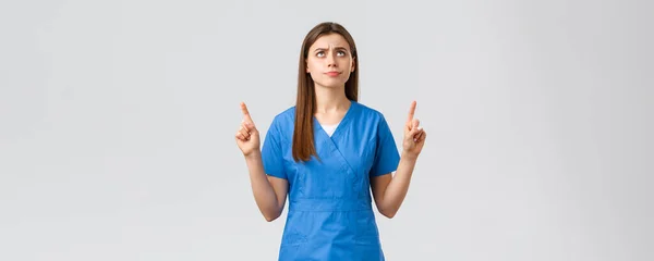 医療従事者,ウイルスを防止します, covid-19テストスクリーニング,医学の概念.不満と動揺若い気分の看護師、青の頭皮の医者、笑顔と眉をひそめ、指を指して — ストック写真