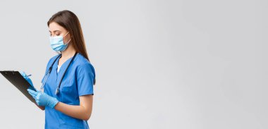 Covid-19, virüsün önlenmesi, sağlık, sağlık çalışanları ve karantina konsepti. Normal hasta kontrolü sırasında profesyonel kadın hemşire ya da doktor, panoya bilgi yazıyorlar.