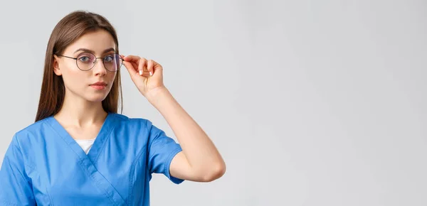 医療従事者、医療、保険およびcovid-19パンデミックの概念。プロフェッショナルスマート女性看護師,医師やインターンブルースクラブとカメラを見て眼鏡を決定,グレーの背景 — ストック写真