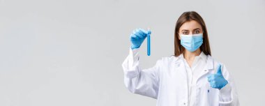 Covid-19, virüsü önleme, sağlık çalışanları ve karantina konsepti. Doktor Coronavirus aşısı testini bitirdi. Test tüpünü numuneyle tutuyor ve onaylıyor. Onaylıyor.