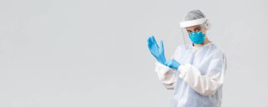 Covid-19, virüsün önlenmesi, sağlık, sağlık çalışanları ve karantina konsepti. Kararlı genç kadın doktor, PPE koruyucu ekipman hemşiresi, maske takan lastik eldivenler, aşı üzerinde çalışan