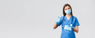 Covid-19, virüsün önlenmesi, sağlık, sağlık çalışanları ve karantina konsepti. Profesyonel kadın hemşire veya doktor mavi önlük ve kişisel koruyucu ekipman, tıbbi maske kullanmanızı önerir