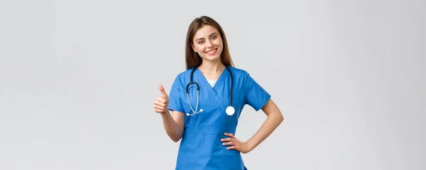 Egészségügyi dolgozók, egészségügy, kovid-19 és oltási koncepció. Vonzó vidám női ápolónő, orvos köpenyben, amely támogatást, ajánlást vagy tanácsot orvoslás, mutassa hüvelykujj-up jóváhagyása mosolygós — Stock Fotó