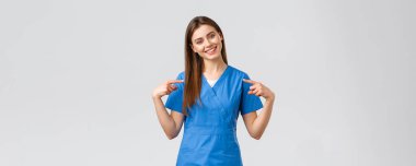 Sağlık çalışanları, virüs ve tıp konseptini engelleyin. Neşeli, gülümseyen güzel doktor, mavi önlüklü kadın hemşire, hastalara yardım etmeye hazır, Coronavirüs 'ten hayat kurtarmaya hazır.