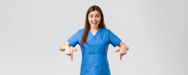 Sağlık çalışanları, virüsü önleyin, covid-19 test taraması, tıp konsepti. Heyecanlı, mutlu, çekici hemşire ya da doktor mavi önlüklü, parmakları aşağıda, büyük bir reklam buldu, afiş gösteriyordu.