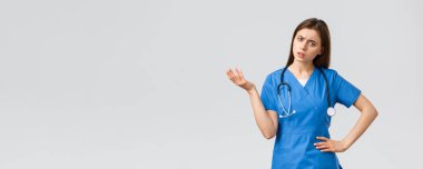 Sağlık çalışanları, virüsü, sigortayı ve ilaç konseptini engelleyin. Şaşkın ve şaşkın kadın hemşire, steteskoplu doktor, omuz silkme ve el kaldırma, kararsız bakışlar, anlayamıyorum.