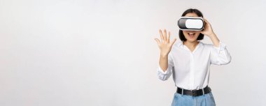 Vr sohbet. Asyalı kız sanal gerçeklik gözlükleriyle merhaba diyor, coşkuyla gülümsüyor, iletişim konsepti ve gelecek teknolojisi, beyaz arka plan