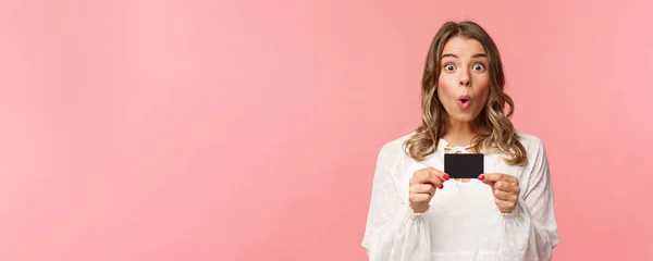 Närbild porträtt av upphetsad och road ung flicka beskriva nya funktioner i hennes bank, fick nya kreditkort, säg wow, vikbara läppar glada och förvånad, stående rosa bakgrund — Stockfoto