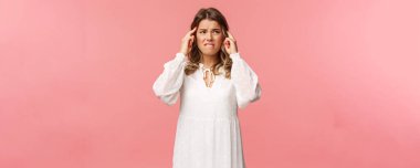 Sarışın, üzgün ve huzursuz bir genç kadının portresi ilkbaharda çiçeklere karşı kötü bir alerjisi vardır, başı döner ve baş ağrısı çeker, tapınaklara bakar, acı veren migrenden, pembe arka plandan yüzünü çevirir.