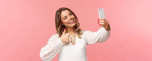 Närbild porträtt av snygga vackra skönhet bloggare spela in video på smartphone, ta selfie, visar tummen upp på mobiltelefon kamera, ler nöjd, rekommenderar plats att följa — Stockfoto