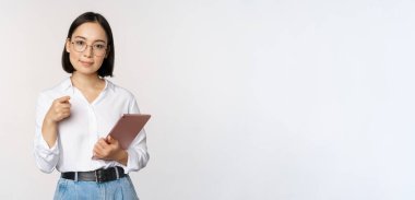 Koreli bir kadın, gözlüklü bir ofis çalışanı, elinde çalışma tableti olan ve seni işaret eden, işe almayı seçen, beyaz arka planda duran