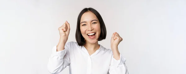 De cerca retrato de la cara de la mujer asiática bailando sonriendo, triunfando y celebrando con emoción feliz, de pie sobre fondo blanco — Foto de Stock