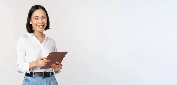 Bild av ung VD manager, koreanska arbetande kvinna som håller tablett och ler, stående över vit bakgrund — Stockfoto