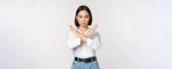 Afbeelding van jonge aziatische, koreaanse meisje student tonen stop, kruis verbod teken, verbieden smth, weigeren, staande over witte achtergrond — Stockfoto