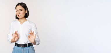 Hayır, teşekkür ederim. Genç, tiksinmiş Asyalı kadın evlenme teklifini reddediyor, el sıkışıyor ve geri çekiliyor. Hoşnutsuzca bakıyor, reddediyor, beyaz arka planda duruyor.