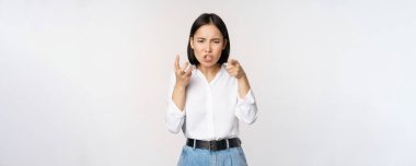 Image of angry pissed off woman shaking from anger, clench hands and grimacing furious, annoyed and outrated, standing over white background