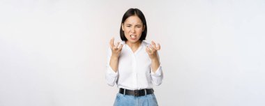 Image of angry pissed off woman shaking from anger, clench hands and grimacing furious, annoyed and outrated, standing over white background
