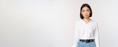Üzgün ofis kızı, somurtkan Asyalı kadın hayal kırıklığına uğramış, üzgün ve sıkıntılı beyaz arka plan