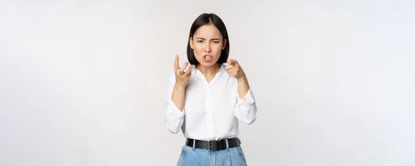 Image of angry pissed off woman shaking from anger, clench hands and grimacing furious, annoyed and outrated, standing over white background — Stockfoto