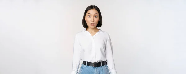 Portré meglepett fiatal irodai nő, ázsiai üzletasszony ziháló csodálkozva, mondván wow, álló lenyűgözte hírek ellen fehér háttér — Stock Fotó
