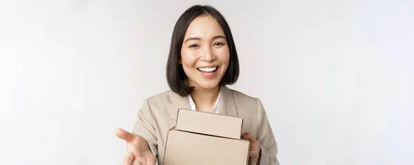 Porträt einer Geschäftsfrau, asiatische Verkäuferin, die auf dich zeigt, Kisten mit Aufträgen gibt, im Anzug vor weißem Hintergrund steht — Stockfoto