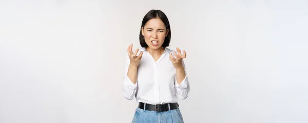 Image of angry pissed off woman shaking from anger, clench hands and grimacing furious, annoyed and outrated, standing over white background — Fotografia de Stock