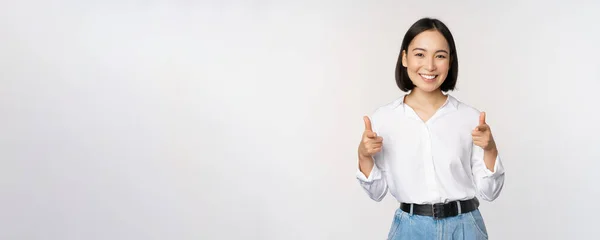 To jsi ty, gratuluju. Usmívající se atraktivní asijská žena, podnikatelka ukazuje prsty na kameru s potěšenou tváří, lichotí, zve vás, stojí nad bílým pozadím — Stock fotografie