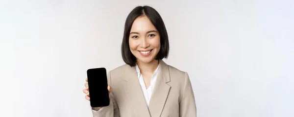 Porträt einer asiatischen Frau mit Smartphone-App-Schnittstelle, Handy-Bildschirm, vor weißem Hintergrund — Stockfoto