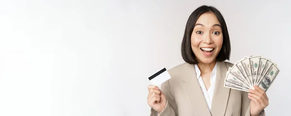 お金とクレジットカードを見せ白い背景の上に立っている熱狂的な若いアジアの実業家 — ストック写真
