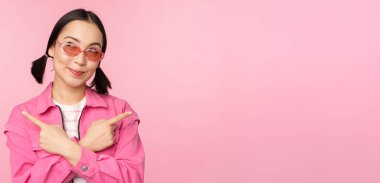 Tercih. Tarz sahibi Koreli bir kız, Asyalı bir kadın model, iki farklı modeli gösteriyor, ürün reklamları, ürünleri gösteren, pembe arka planda duran