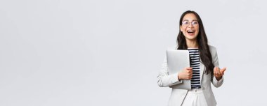 İş, finans ve istihdam, başarılı kadın girişimciler konsepti. Gülen profesyonel iş kadını, emlak komisyoncusu müşterilere iyi bir anlaşma gösteriyor, elinde laptop taşıyor.