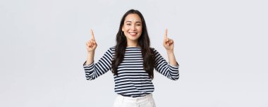 Yaşam tarzı, güzellik ve moda, insanların duygu konsepti. Neşeli, güzel bir bayan model. Parmakla reklam afişini işaret ediyor. Gülümseyen kamera, çevrimiçi mağazaya bağlantı kurulmasını öneriyor.