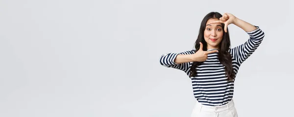 Estilo de vida, emociones de la gente y concepto casual. Creativo lindo asiático chica foto, captura momento con marcos de mano gesto, sonriendo divertido, mantenerse positivo y feliz, fondo blanco — Foto de Stock