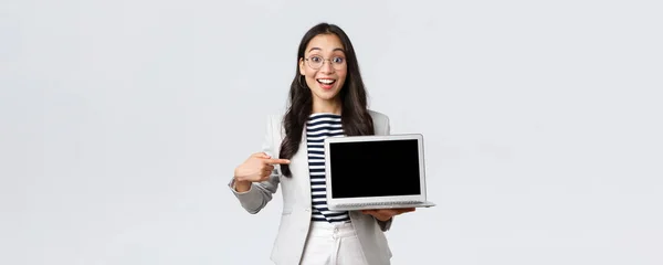 Negocios, finanzas y empleo, concepto de emprendedoras exitosas. Entusiasta gerente de oficina mostrando su presentación en el ordenador portátil, apuntando a la pantalla y sonriendo divertido —  Fotos de Stock