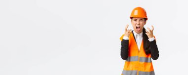 Kızgın ve öfkeli Asyalı kadın baş mühendis, inşaat müdürü öfkeden kudurdu, çalışanlara öfkelendi, bağırdı ve el sıkıştı, birini azarlarken öfkeli bir şekilde çığlık attı.