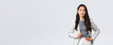 İş, finans ve istihdam, başarılı kadın girişimciler konsepti. Kibirli ve kendinden emin Asyalı genç iş kadını etkilenmemiş görünüyor, şüpheci bir sırıtış yap.