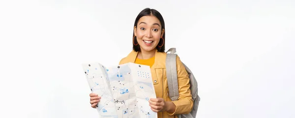 Изображение молодой азиатки туристки, путешественницы с картой и рюкзаком позируют на белом фоне студии — стоковое фото