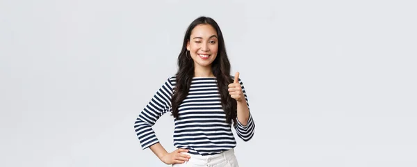 Estilo de vida, belleza y moda, concepto de emociones de la gente. alegre lindo asiático chica thumb-up en aprobación, guiño alentador y sonriente, alabando buen trabajo, decir bien jugado como felicitar con ganar — Foto de Stock