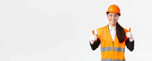 Satisfeito sorridente feminino asiático chefe engenheiro de construção dando permissão para entrar no edifício ou entertprise depois de usar roupas de segurança, luvas de óculos e capacete, mostrando polegar-up na aprovação — Fotografia de Stock