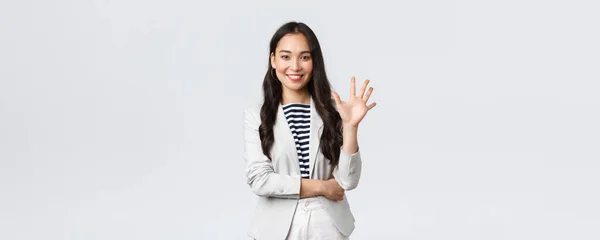 Unternehmen, Finanzen und Beschäftigung, erfolgreiche Unternehmerinnen. Erfolgreiche Geschäftsfrau, asiatischer Immobilienmakler mit erhobenem Zeigefinger, Nummer fünf und lächelnd — Stockfoto