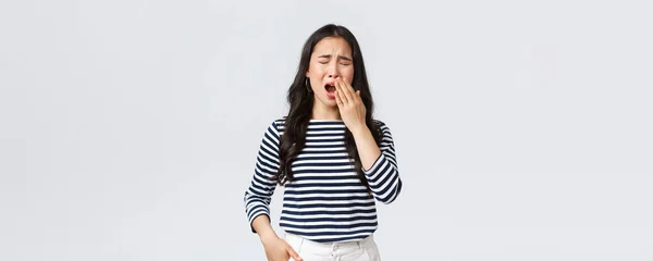 Stile di vita, emozioni della gente e concetto casuale. Donna stanca assonnata che lavora fino a tardi in ufficio, chiude gli occhi e sbadiglia, vuole andare male. Asiatico ragazza svegliato presto, bisogno di caffè, stand bianco sfondo — Foto Stock