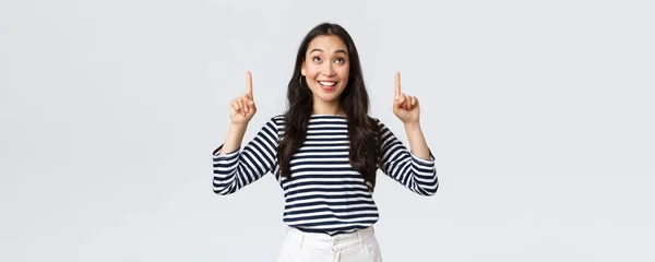 라이프 스타일, 사람들의 감정 개념. 훌륭 한 제품을 발견 해 기쁘게 웃고, 광고에 손가락을 들고 만족 해 하는 명랑 한 동양 소녀가 프롬을 추천 한다. — 스톡 사진