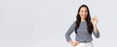 Yaşam tarzı, güzellik ve moda, insanların duygu konsepti. Tatmin olmuş güzel bir kadın ürünün kalitesini garanti ediyor, reklam öneriyor, tamam işareti gösteriyor, sorun yok, her şey yolunda.