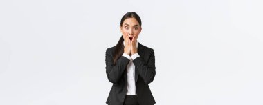 Endişeli Asyalı iş kadını sıkıntılı bir durumla karşı karşıya, çenesini indir ve kameraya bak, ne yapacağını bilmiyor, panikliyor ve titriyor, beyaz arka planda duruyor.