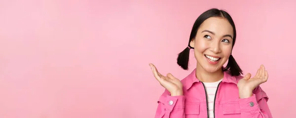 Έννοια φροντίδας δέρματος και κοσμετολογίας. Όμορφο κορίτσι από την Ασία χαμογελώντας και γελώντας, δείχνει καθαρό υγιές δέρμα του προσώπου, ποζάροντας σε ροζ φόντο — Φωτογραφία Αρχείου